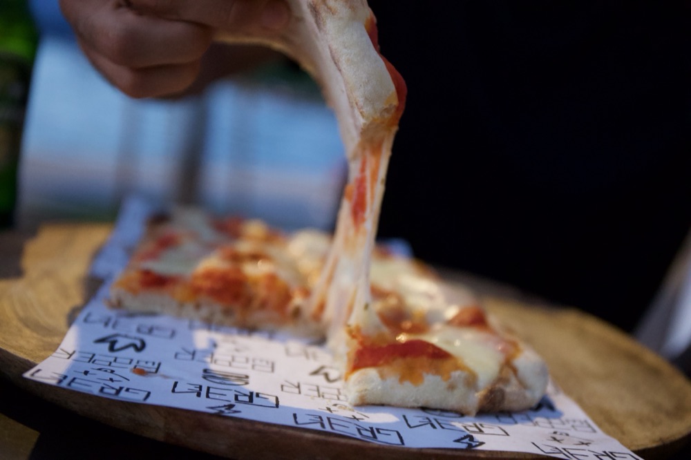 Un trancio di pinsa con la mozzarella filante